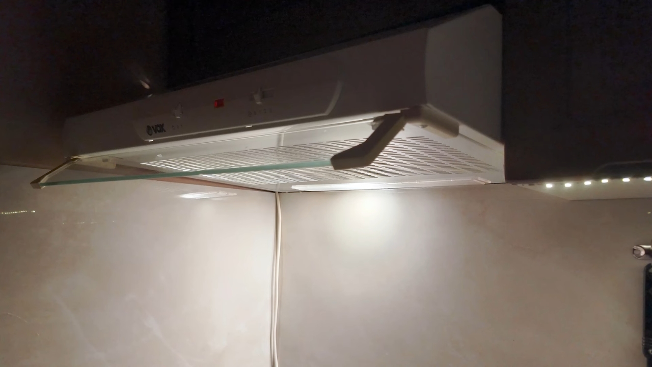 VOX zidni aspirator postavljen ispod kuhinjskog elementa sa uključenim svetlom i vidljivim filterom