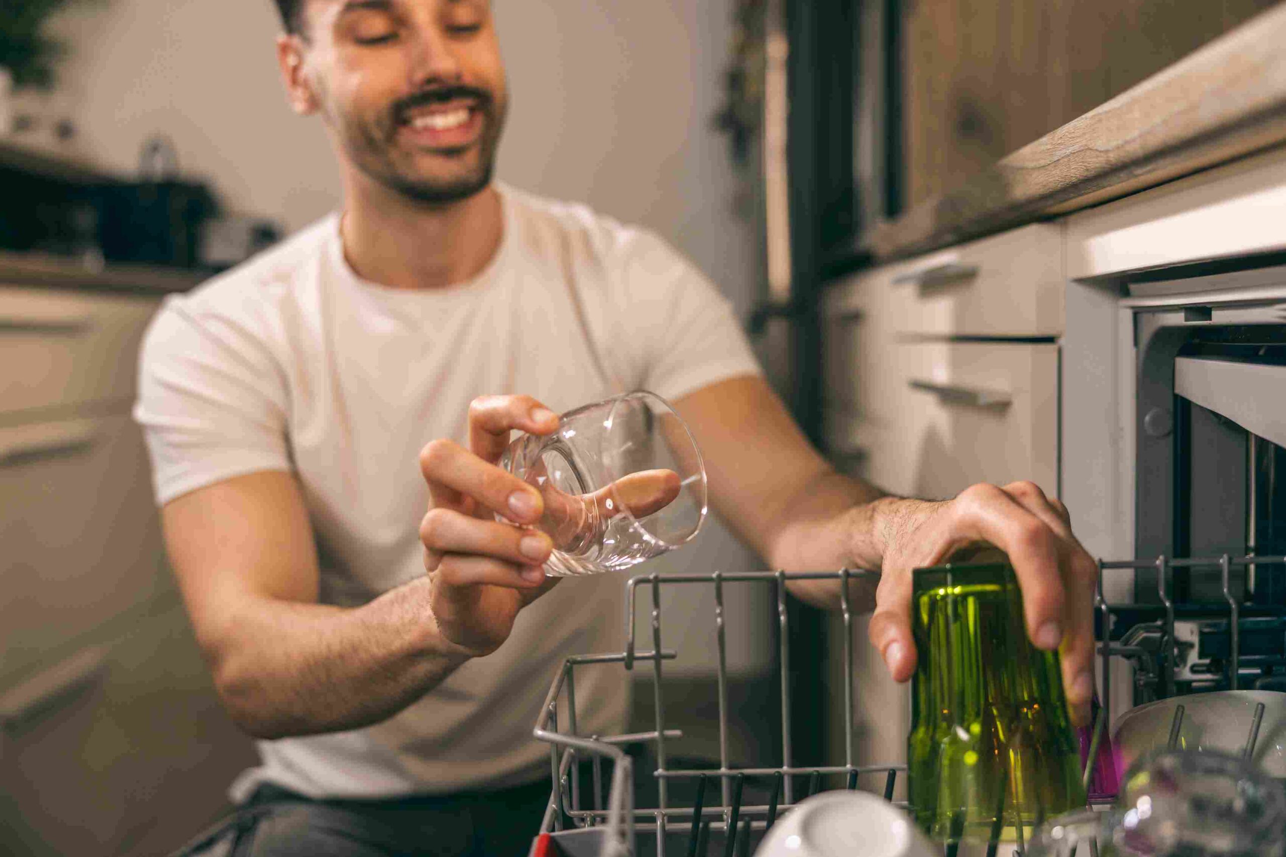 Muškarac slaže čaše u mašinu za sudove