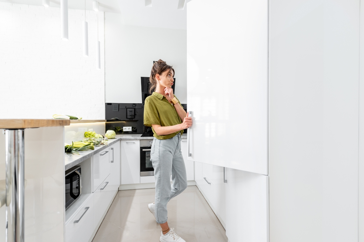 devojka gleda u frižider