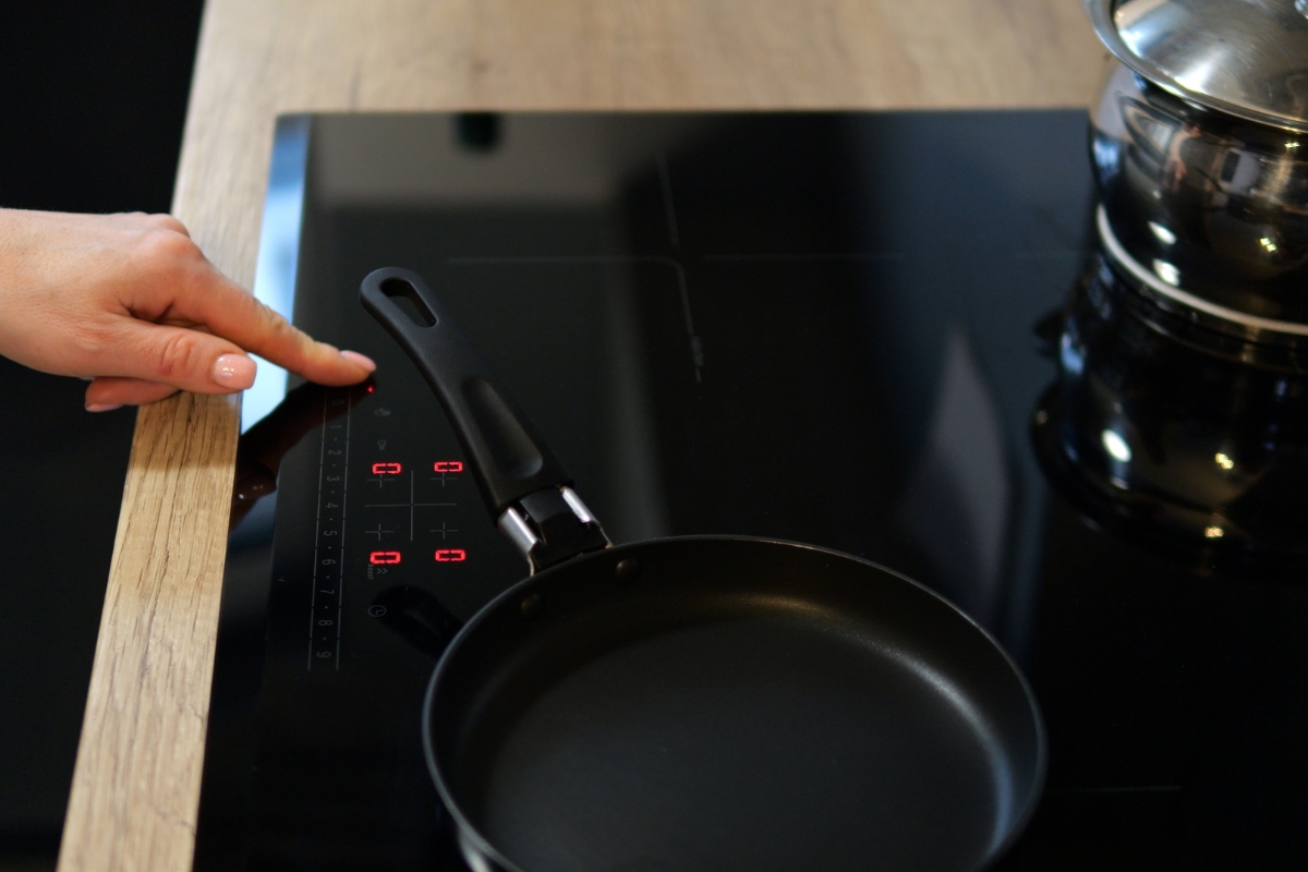 osoba koristi indukcionu ploču