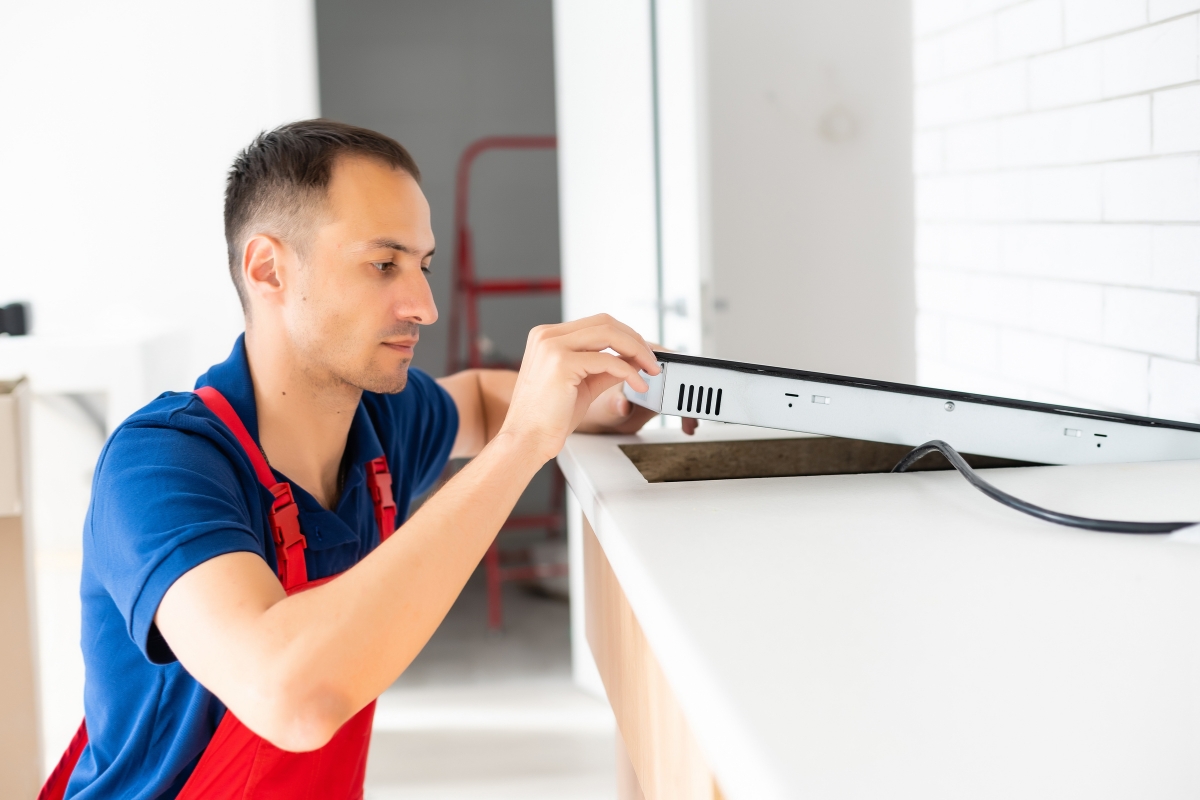 prikaz majstora koji popravlja indukcionu ploču