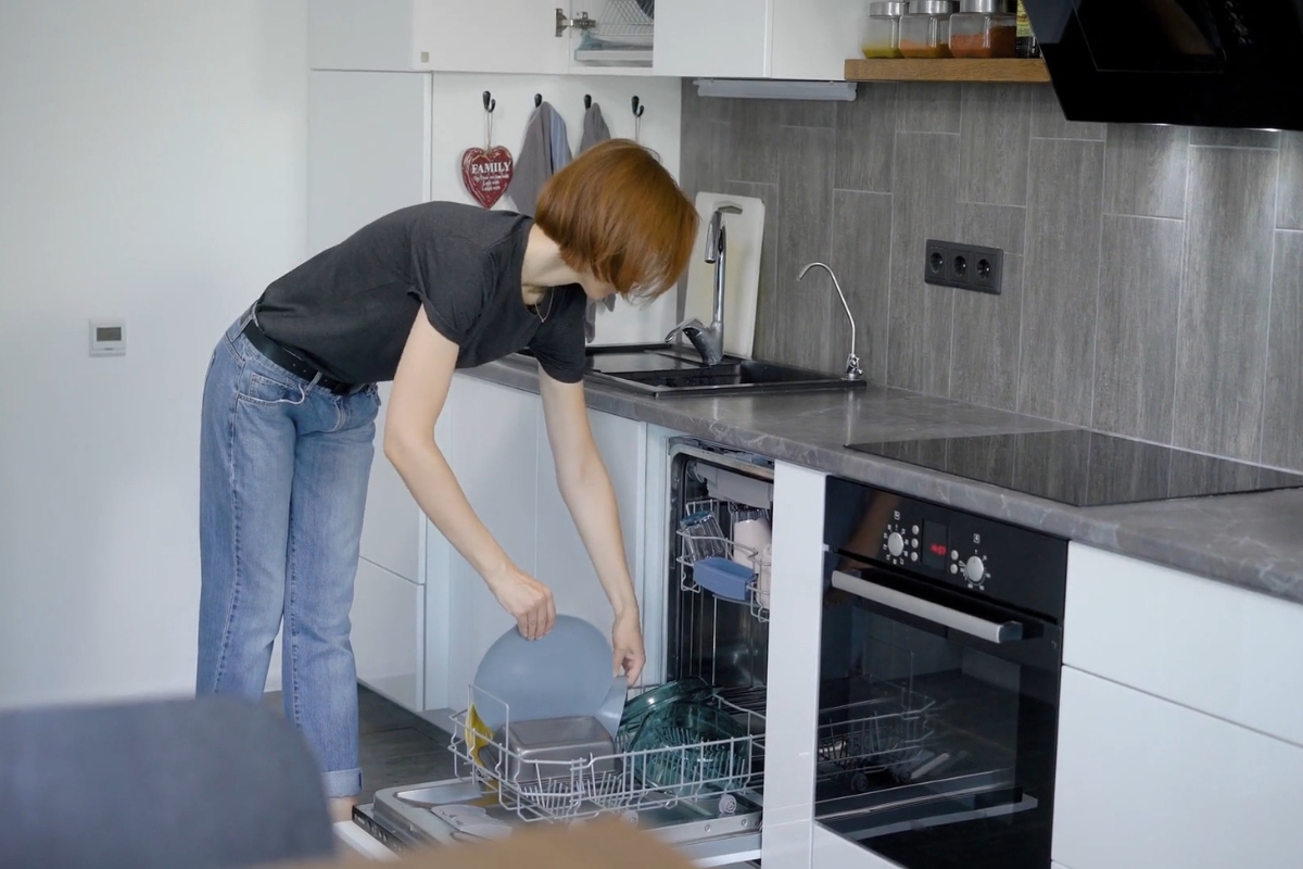 devojka vadi sufove iz mašine za sudove