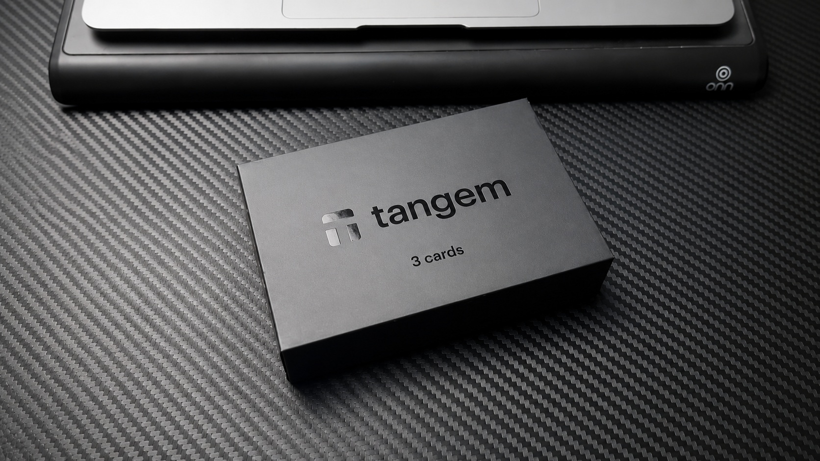 Tangem pakovanje sa tri hardverske kartice za sigurno skladištenje kriptovaluta pored laptopa