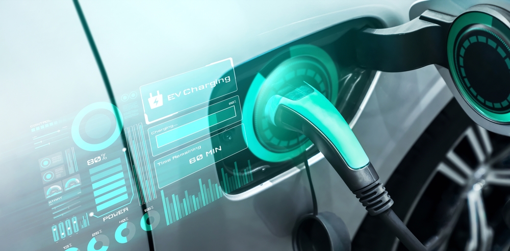 Električni automobil priključen na savremeni wallbox punjač sa prikazom podataka o punjenju i brzini prenosa energije.
